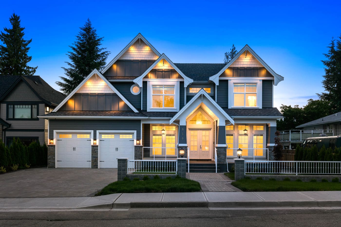 Craftsman-style home at dusk with interior lights on