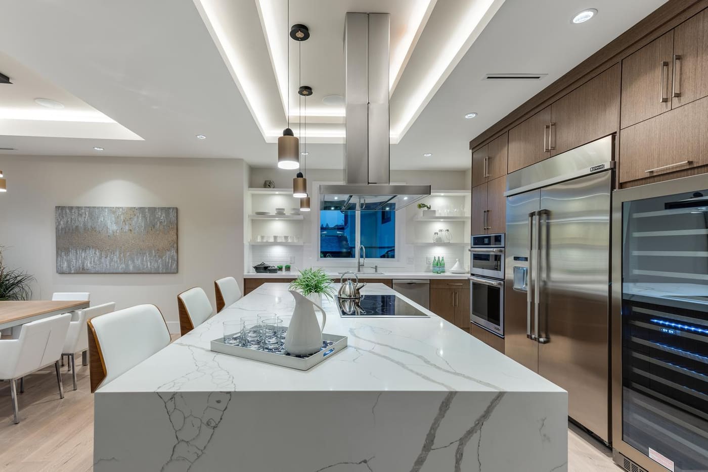 Kitchen with a marble waterfall island, walnut cabinetry, and a built-in wine fridge